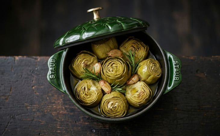 Alcachofas confitadas en aceite de oliva dentro de una Cocotte Staub de hierro fundido